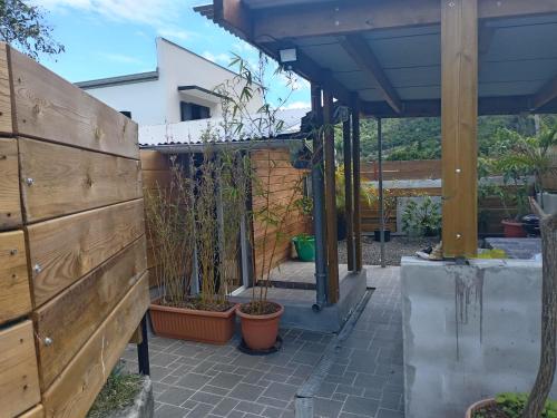 un patio con macetas y una valla de madera en Le cerisier, en Entre-Deux