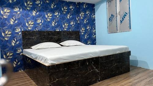Cama en habitación con pared azul en KRISHNA P. GUEST HOUSE en Varanasi