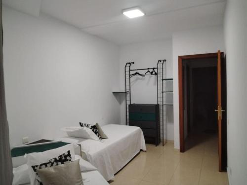 Habitación blanca con cama y espejo en Ca'Xexu en Telde