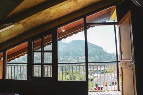a room with a window with a view of a mountain at JOYstels Kasol in Kasol