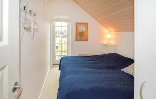 a bedroom with a blue bed and a window at Shjlandet in Gjern