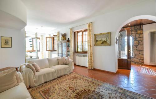 a living room with a white couch and some windows at Nice Apartment In Rogno With Wifi in Rogno