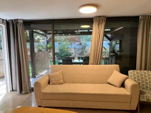 a living room with a couch and a large window at Luxury suite in the best, calmest part of Tel Aviv in Tel Aviv