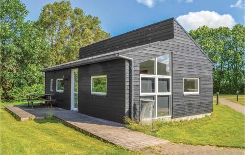 a black tiny house with a patio at Holiday Home Halvejen Hytte Spjald Ii in Spjald