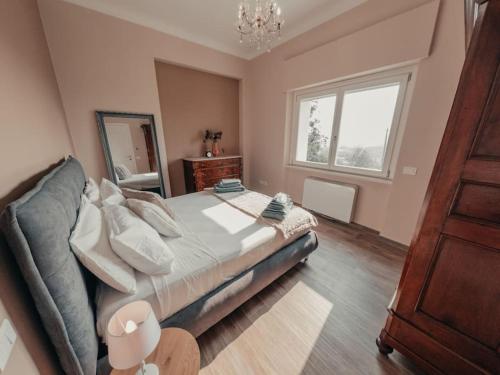 a bedroom with a large bed and a window at Villa Luxury Vista Vigneti-Piscina Privata in Agliano Terme