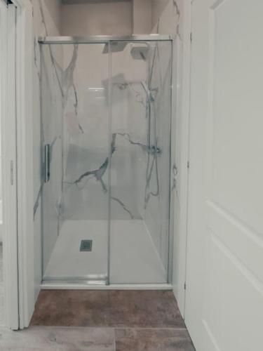 a glass shower door in a white room at Villa Luxury Vista Vigneti-Piscina Privata in Agliano Terme