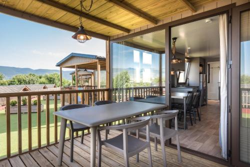 un patio con tavoli e sedie su una terrazza di Bungalows Stel-Puigcerdà a Puigcerdà