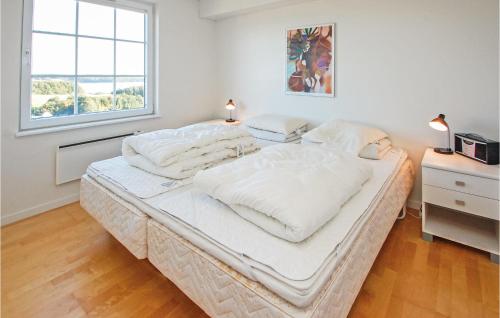 ein großes weißes Bett in einem Zimmer mit Fenster in der Unterkunft Amazing Home In Aabenraa With Kitchen in Danland Løjt