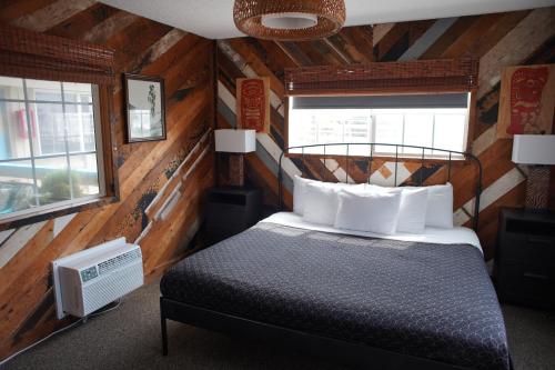 a bedroom with a bed in a room with wooden walls at Huntington Surf Inn in Huntington Beach