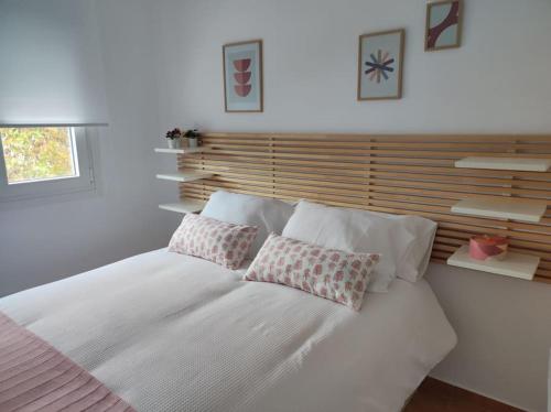 a bedroom with a white bed with two pillows on it at Apartamento Puerto Chico in El Puerto de Santa María