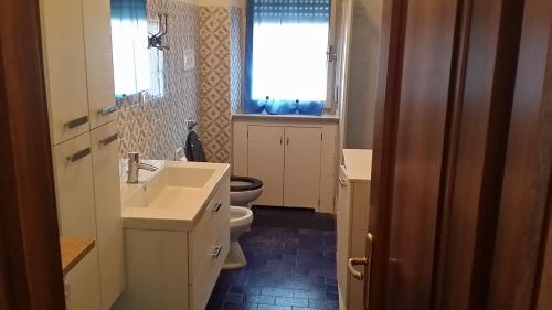 a bathroom with a sink and a toilet and a window at Casa Farinati 2 in Verona