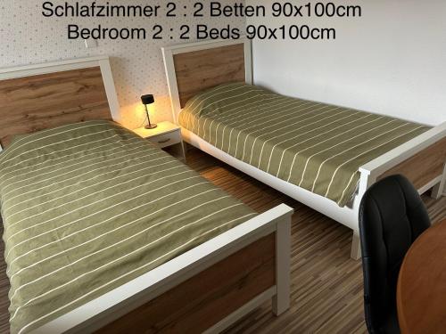 a bedroom with two beds and a table at Diah's Apartment in BEUERN - für Monteure in Felsberg