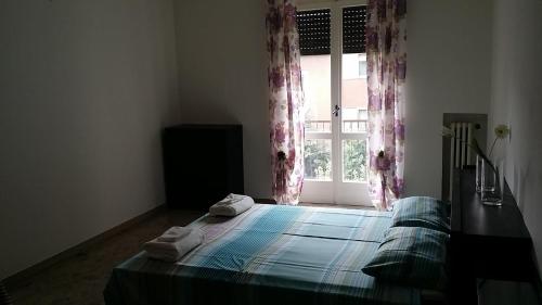 a bedroom with a bed and a window with curtains at Casa Farinati 2 in Verona