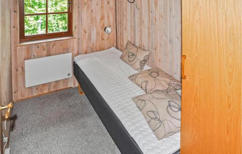 EgernsundにあるAwesome Home In Egernsund With 3 Bedrooms, Sauna And Wifiの木製の部屋にベッド1台が備わるベッドルーム1室があります。
