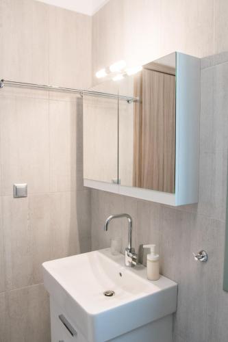 a white bathroom with a sink and a mirror at EMERALD AGIOS NIKITAS in Drymon