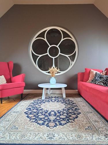 a living room with two red couches and a table at Ark van Thesinge in Thesinge