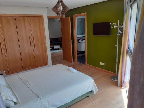 a bedroom with a white bed and a green wall at Casablanca Marina by Saloua in Casablanca