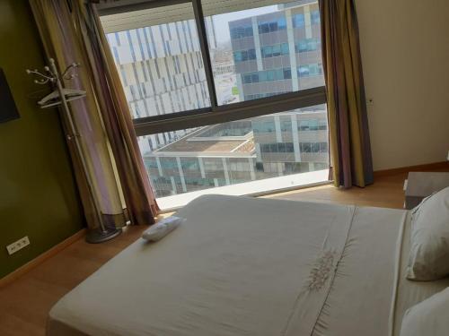 a bed in a room with a large window at Casablanca Marina by Saloua in Casablanca