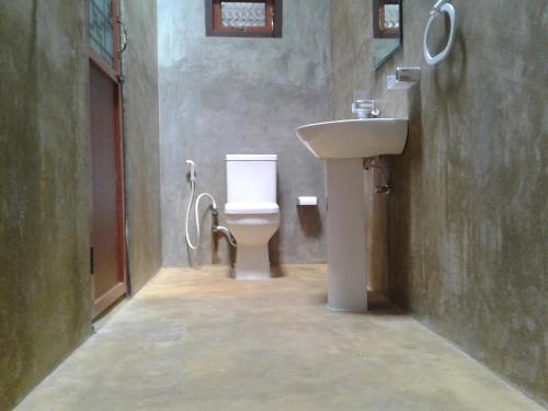 a bathroom with a toilet and a sink at Negombo The Nature Villa and Cabanas in Negombo