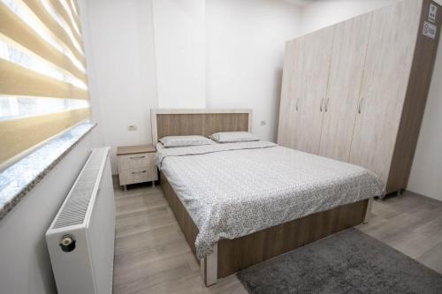 a bedroom with a large bed and a wooden cabinet at AStar Apartments - LARGE in Rădăuţi