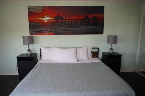 a bedroom with a bed with a painting on the wall at Huntington Surf Inn in Huntington Beach