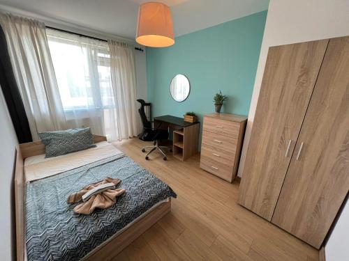 a bedroom with a bed with a dresser and a desk at Al Malina City Family Apt with Parking Space in Sofia