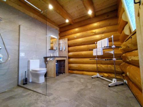 a bathroom with a toilet and a shower with wooden walls at Chalet Helen Deluxe Zimmer in Bad Goisern