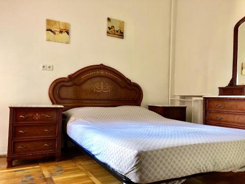 1 dormitorio con 1 cama de madera y 2 vestidores en Comfortable apartments near Gulliver, en Kiev