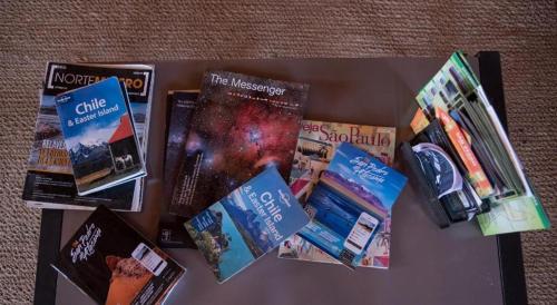 una mesa cubierta con libros y revistas sobre una mesa en Hostal Katarpe, en San Pedro de Atacama