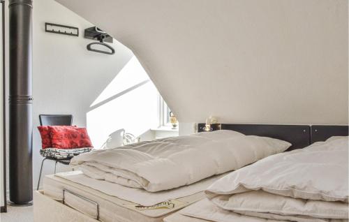 萊姆維的住宿－Cozy Apartment In Lemvig With Kitchen，一间卧室配有两张床和椅子