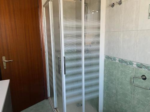 um chuveiro com uma porta de vidro na casa de banho em Appartamento Scarlett em Villafontana