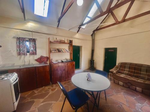 Lindy's Guesthouse في ماسيرو: غرفة معيشة مع طاولة وأريكة