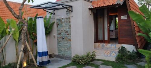 a white house with a flag outside of it at Kori Maharani Villas & Resort in Keramas