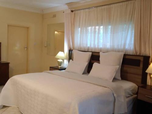 Ένα ή περισσότερα κρεβάτια σε δωμάτιο στο Charming 6-Bed House with Swimming Pool in Harare