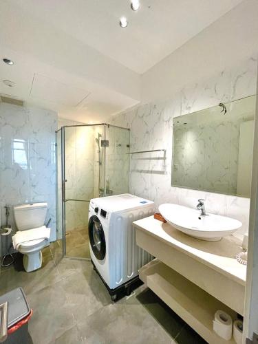 a bathroom with a washing machine and a sink at The Rixx BENTHANHTOWER in Ho Chi Minh City