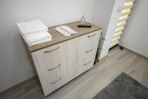 - une commode en bois avec des serviettes dans la chambre dans l'établissement AStar Apartments - LARGE, à Rădăuţi