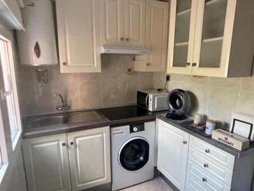 a kitchen with a washing machine and a microwave at Doamvid Universidad in Ciudad Real