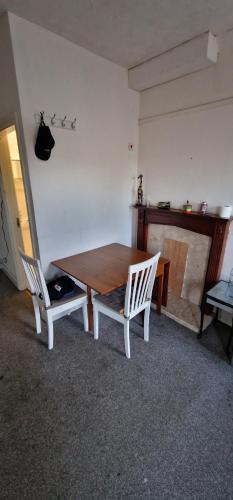 a table and two chairs in a room with a fireplace at 1 bed entire Studio Flat 10 min from City centre in Liverpool