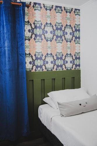 a bedroom with a bed with a blue curtain at hotel velero cavancha in Iquique