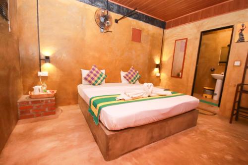 a bedroom with a bed with a towel on it at Negombo The Nature Villa and Cabanas in Negombo