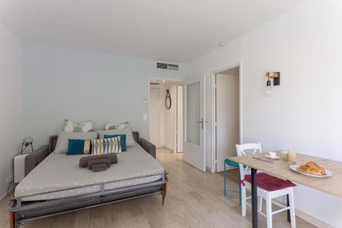 un salon avec un lit et une table dans l'établissement Cosy studio - Centre Cannes - Terrasse - Clim - Wifi, à Cannes
