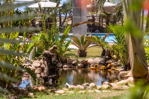 a pond in the middle of a garden at Atlantic Palace Family inn in Aquiraz