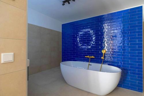uma casa de banho com uma banheira branca numa parede azul em Hotel Stad aan Zee Vlissingen em Vlissingen