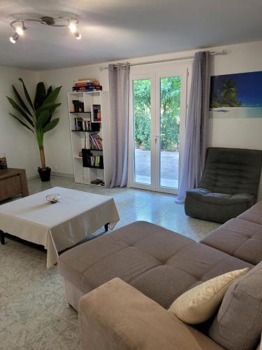 un salon avec un canapé et une table dans l'établissement Bas de villa F3 proche Ajaccio, à Cuttoli-Corticchiato