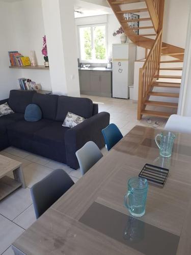 a living room with a table and a blue couch at Maison avec terrasse à 15 minutes de Disney in Nanteuil-lès-Meaux