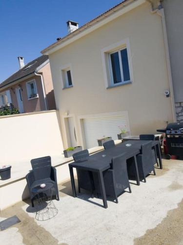 a group of black tables and chairs in front of a building at Maison avec terrasse à 15 minutes de Disney in Nanteuil-lès-Meaux