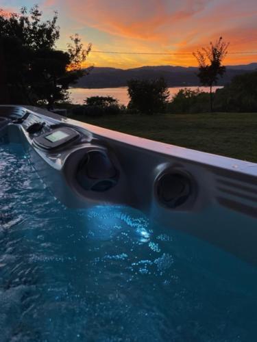 une grande piscine avec vue sur le coucher du soleil en arrière-plan dans l'établissement Gîte Au Coeur Du Noyau, à Aiguebelette-le-Lac