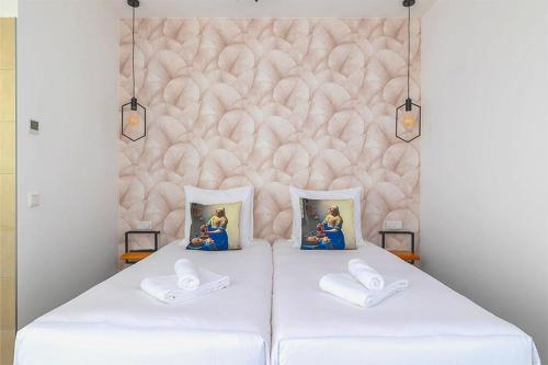 a bedroom with two beds with two pictures on the wall at Boutique Hotel Maldegem in Vlissingen