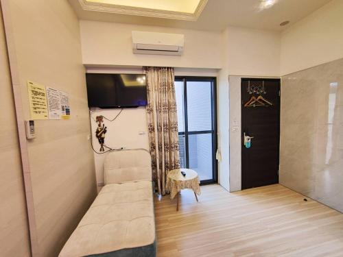 een kamer met een bank, een tv en een raam bij 晢宿民宿 Lucent Bed & Breakfast in Magong