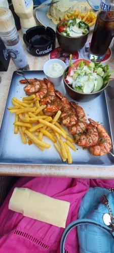 a table with two plates of food with french fries at Studio Julian in Middelkerke